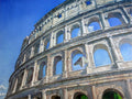 Partial view of the Colosseum against a blue sky
