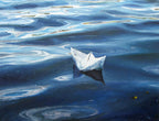 Paper boat floating on water with ripples