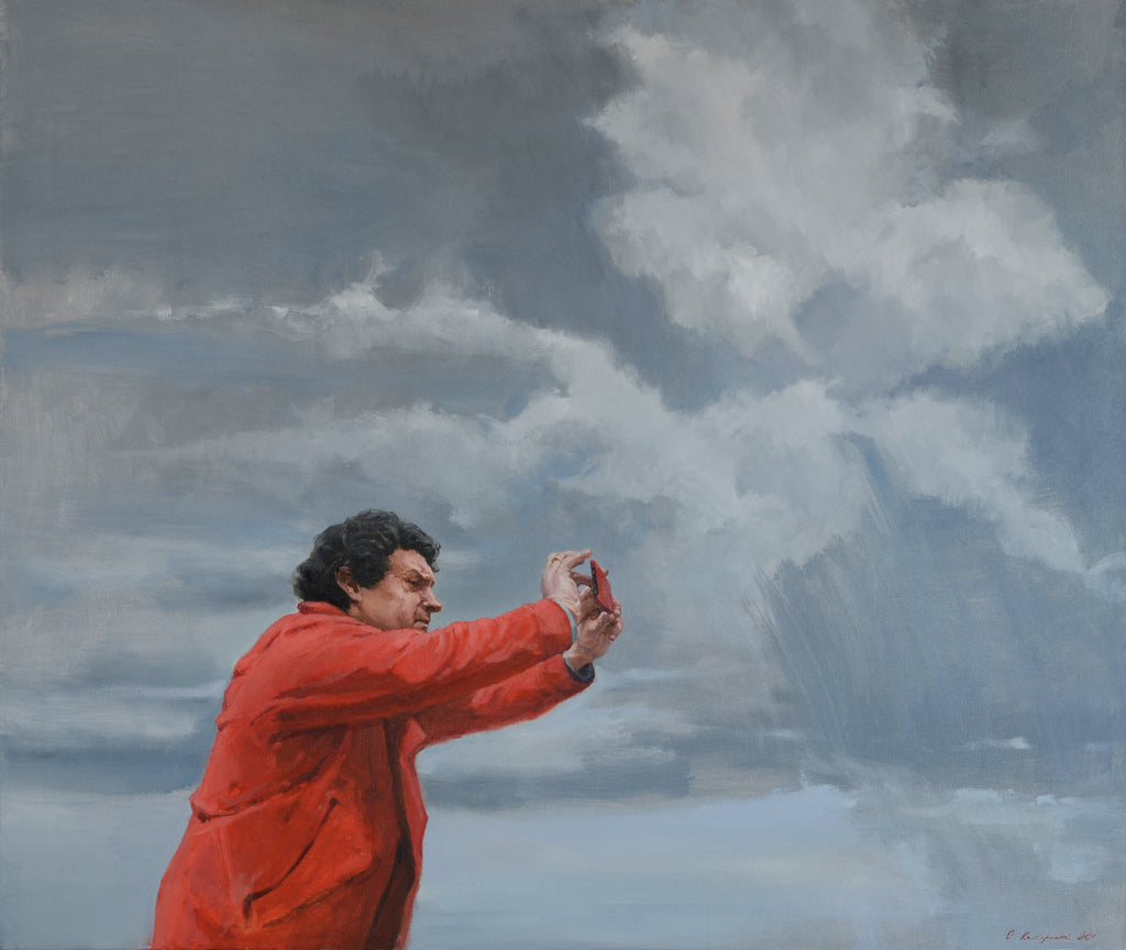 Man in a red jacket against a dramatic sky with clouds