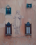 Statue on a textured wall with decorative windows