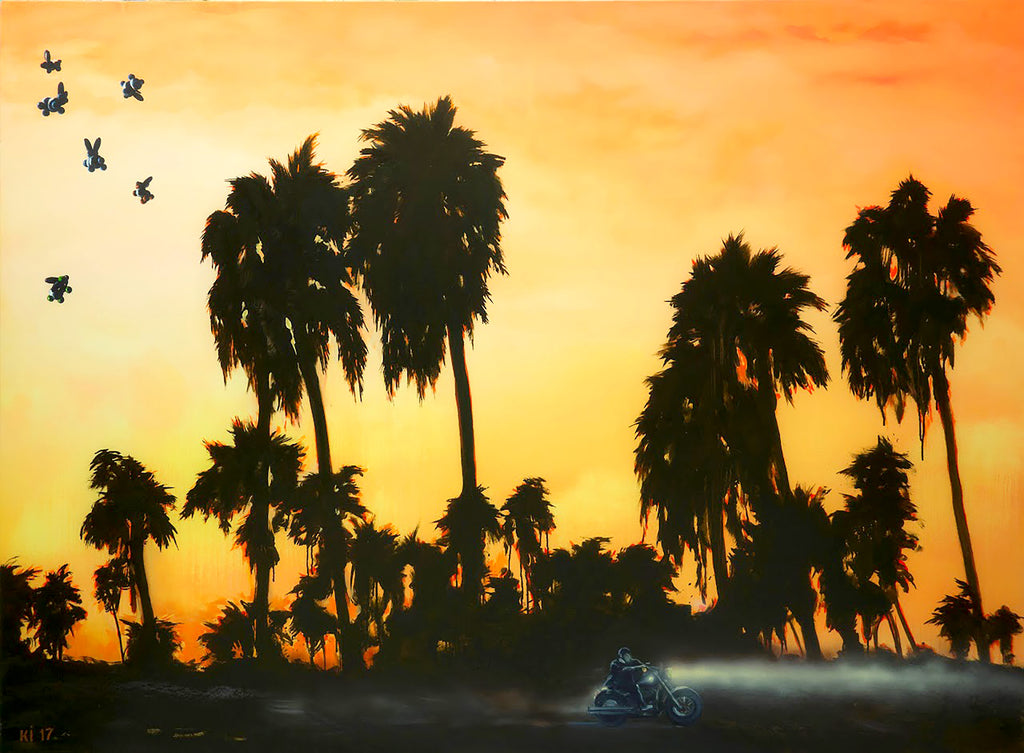 Silhouettes of palm trees against an orange sunset sky with birds flying.