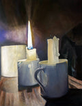 Candle and mugs on a wooden surface with a dark background