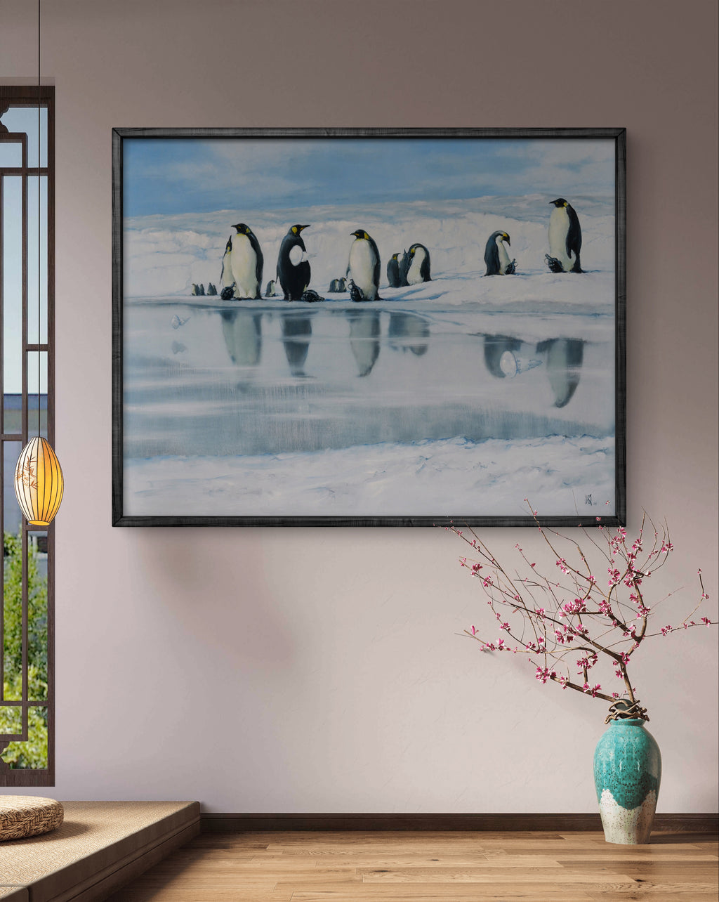 Framed artwork of penguins on ice in a room with a vase and decorative lamp.