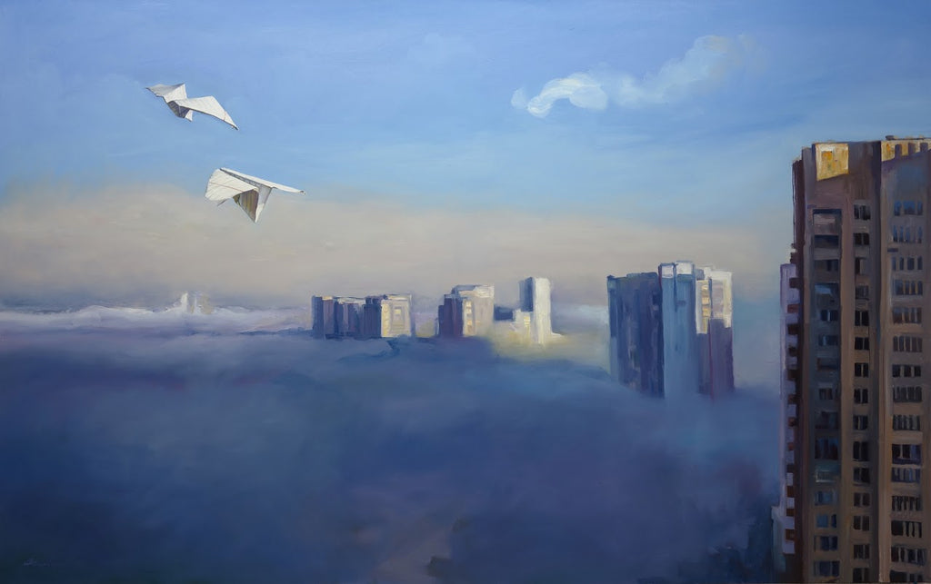 Two white birds flying over a cityscape shrouded in fog with modern buildings.