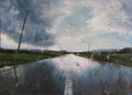 Raindrops on a car window with a view of a rural landscape.