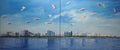 Two panels of a painting showing a city skyline with birds flying over water.