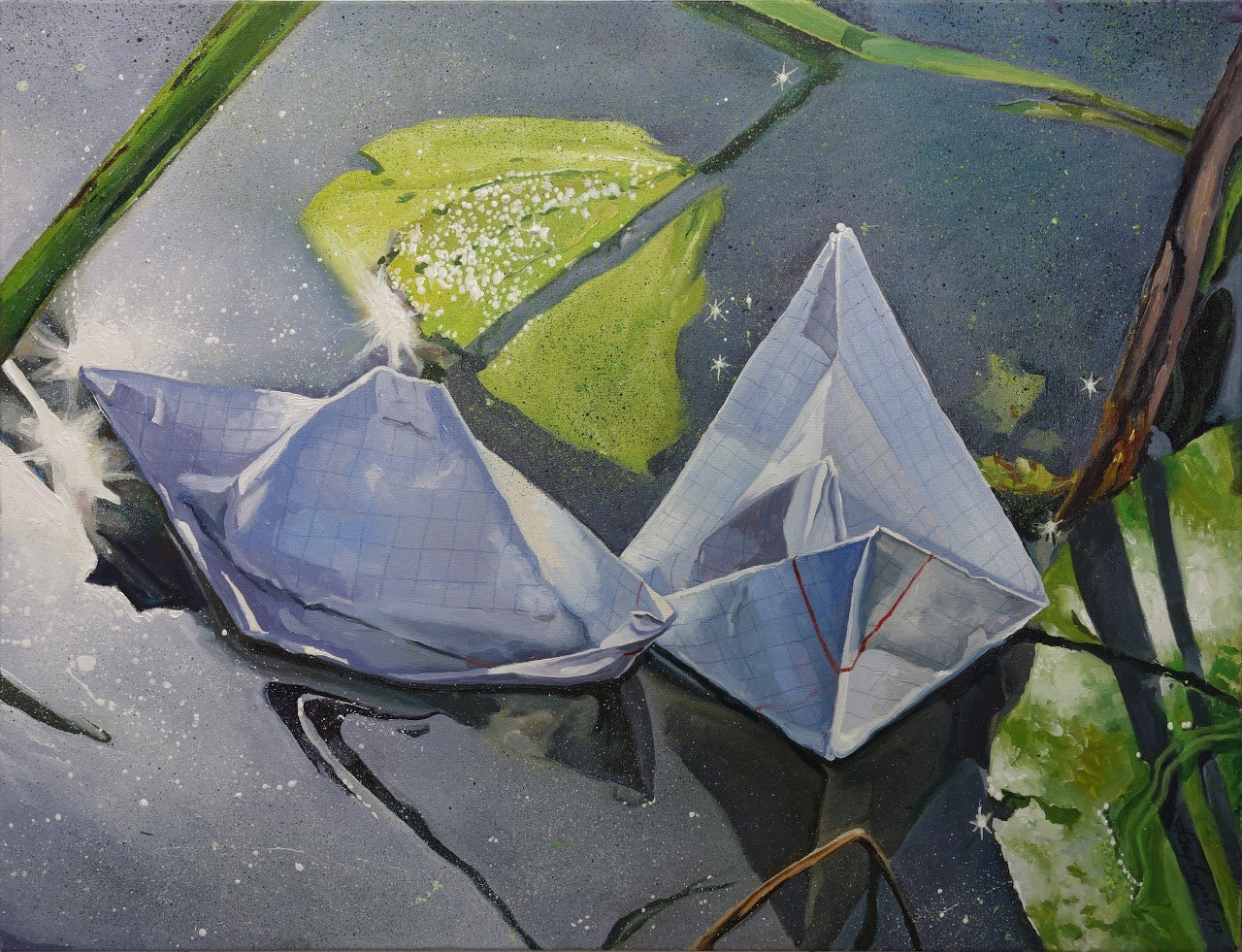 Two paper cranes on a reflective surface with green leaves in the background