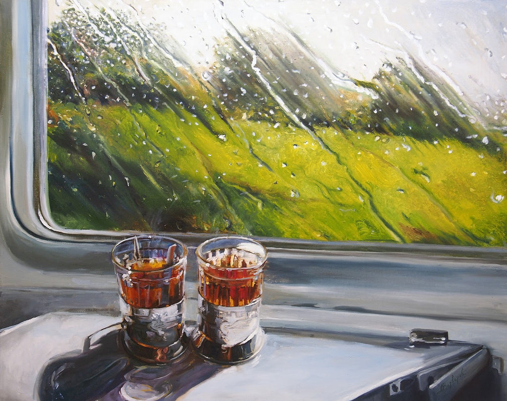 Two shot glasses with a dark liquid on a window ledge, with a blurred green landscape outside.