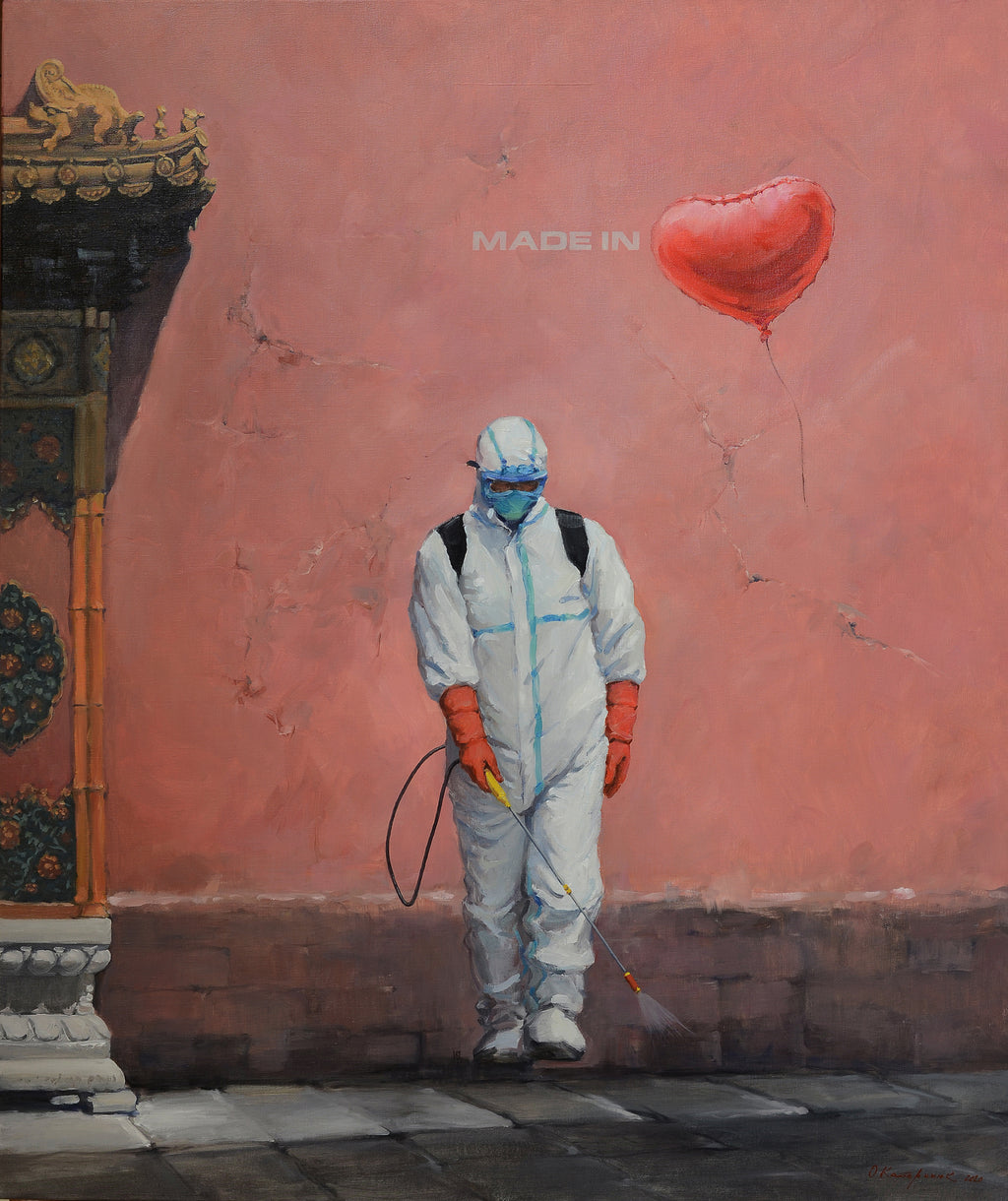 Person in protective suit holding a red heart-shaped balloon against a pink wall with 'MADE IN' text.
