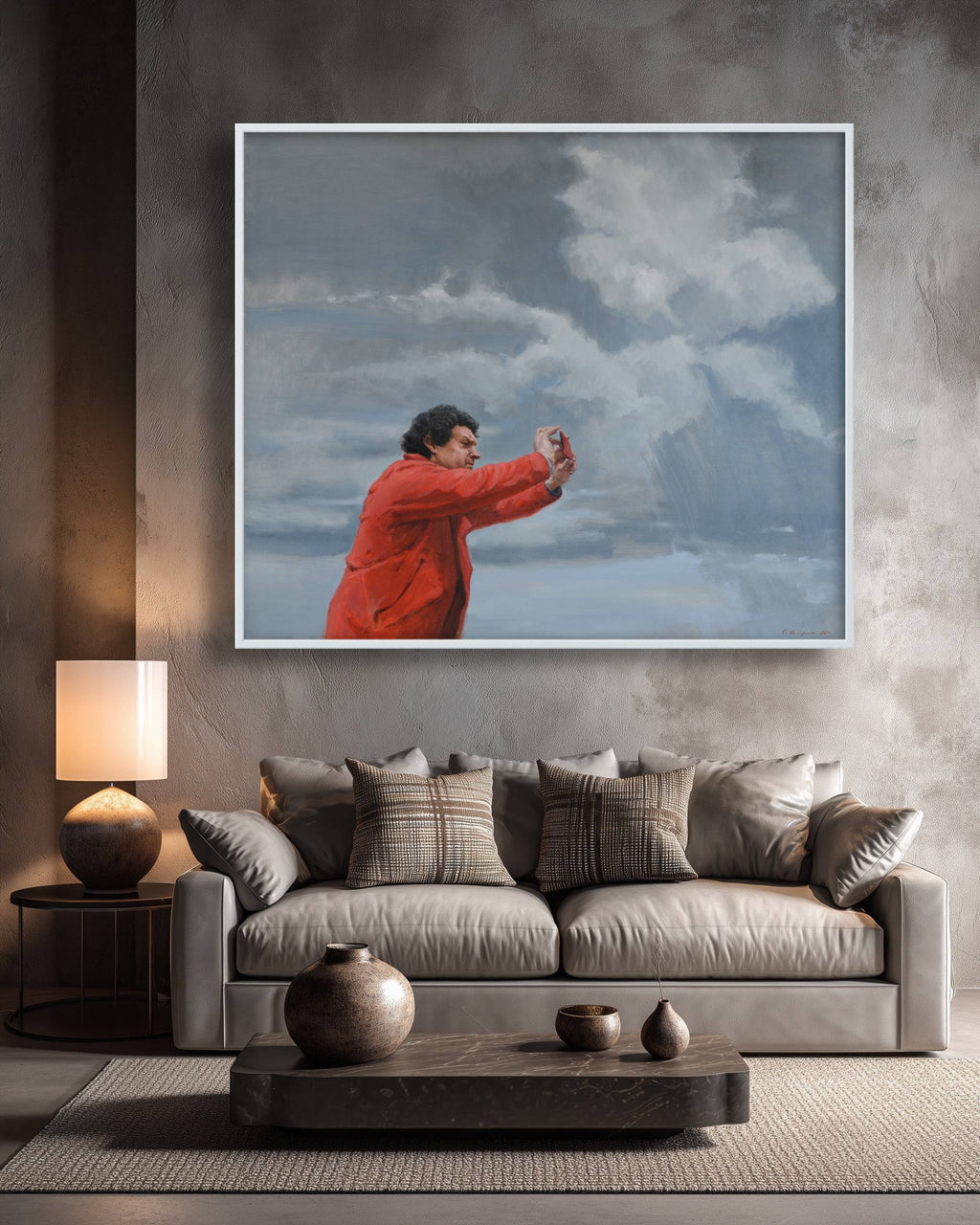 Living room with a gray sofa, decorative pillows, and a large painting of a person in an orange coat against a blue sky.