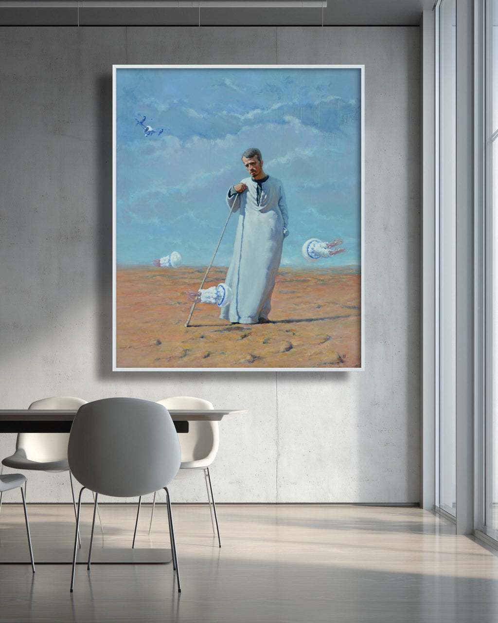Framed painting of a man in a desert landscape with futuristic elements, hanging on a wall above a dining table.