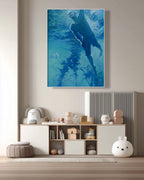 Framed artwork of a person underwater on a wall above a shelf with decorative items.