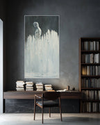 Modern office setup with a desk, chair, and large framed artwork on a dark wall.