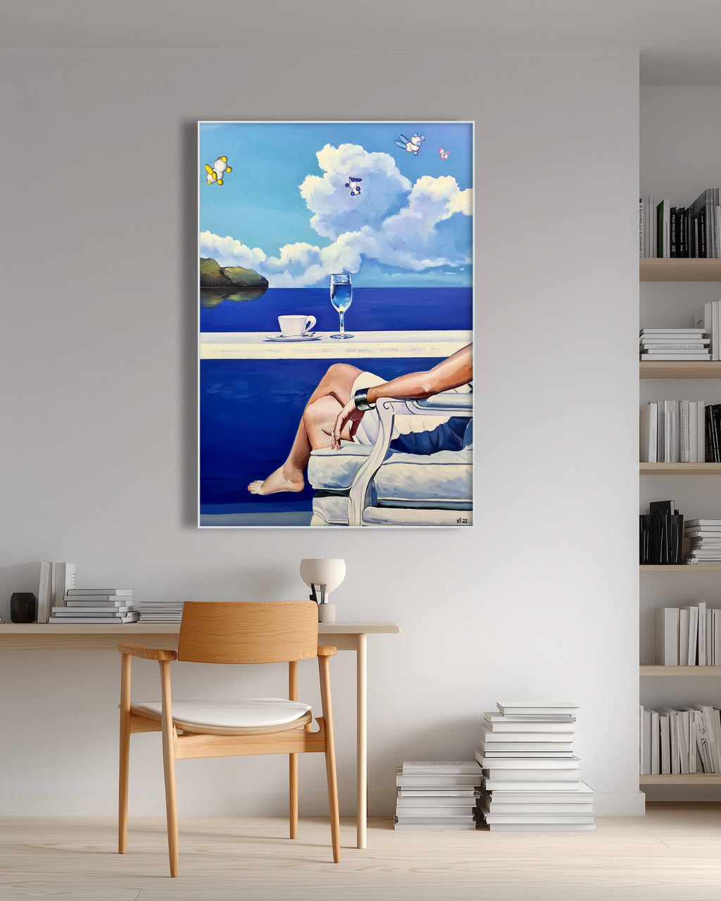 Framed artwork of a person by a pool with a glass of wine and a book, displayed on a wall above a wooden chair.