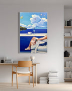 Framed artwork of a person by a pool with a glass of wine and a book, displayed on a wall above a wooden chair.