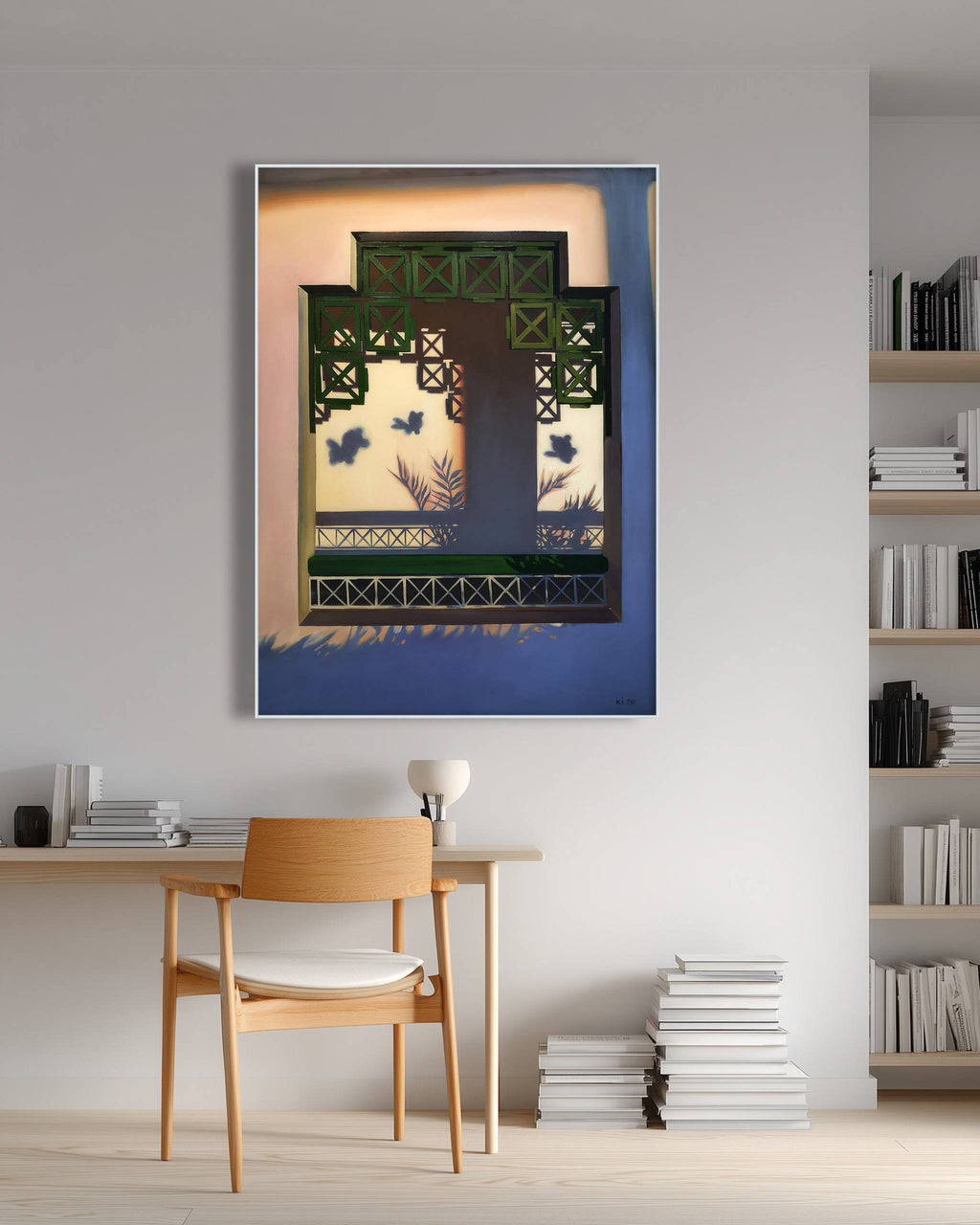 Framed artwork on a wall above a wooden chair in a room with shelves and books.