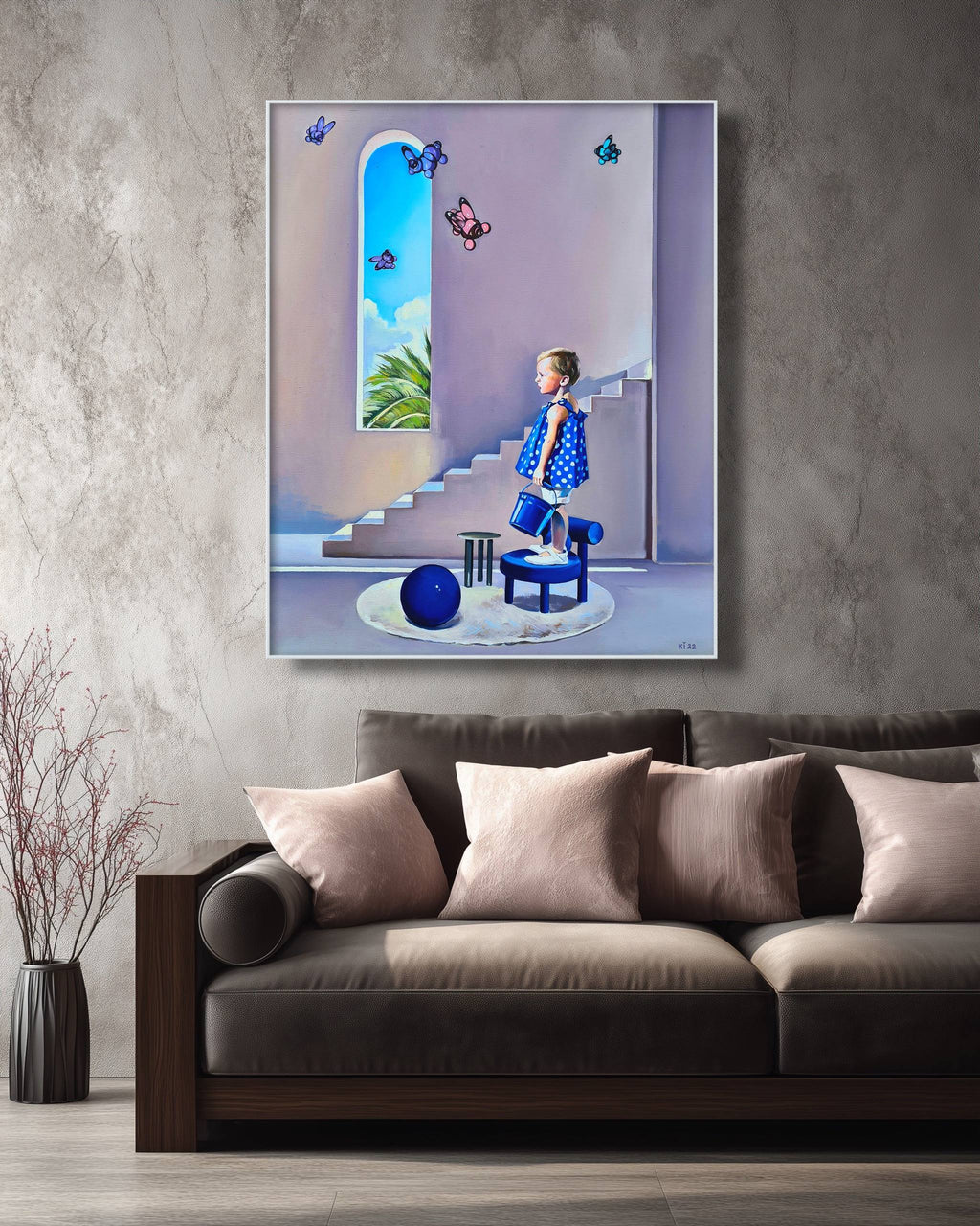 Framed artwork of a girl in a polka dot dress on a wall above a sofa.