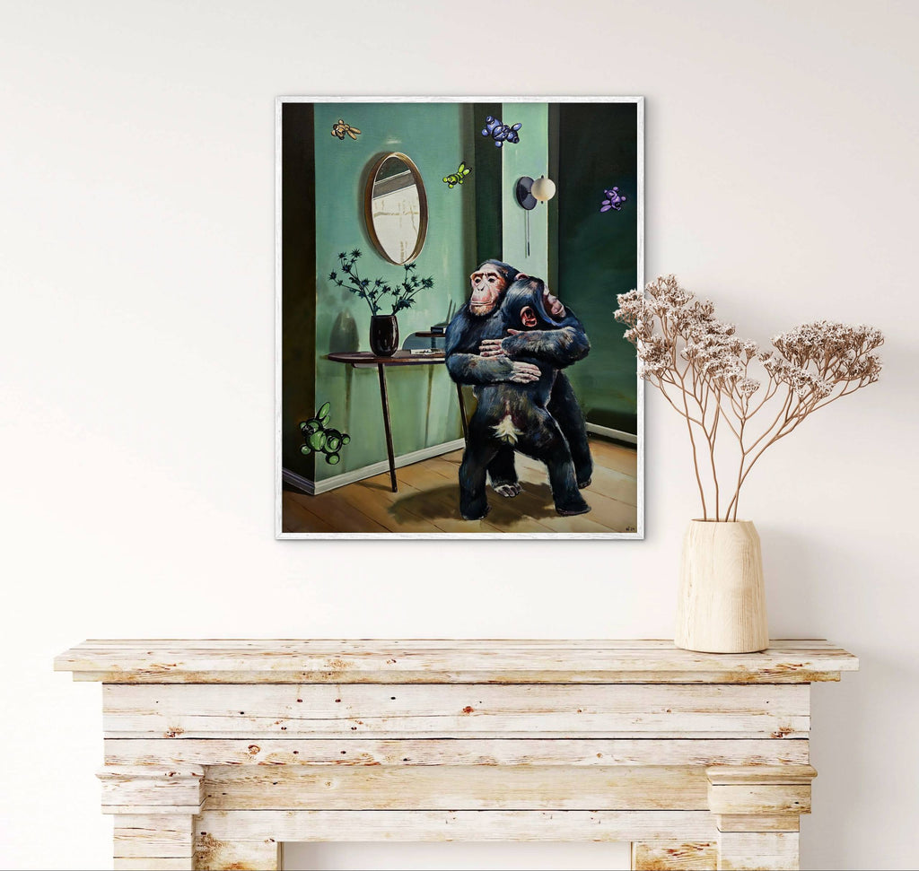Framed artwork of a chimpanzee holding a baby chimpanzee on a wall above a wooden console table.
