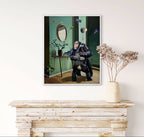 Framed artwork of a chimpanzee holding a baby chimpanzee on a wall above a wooden console table.