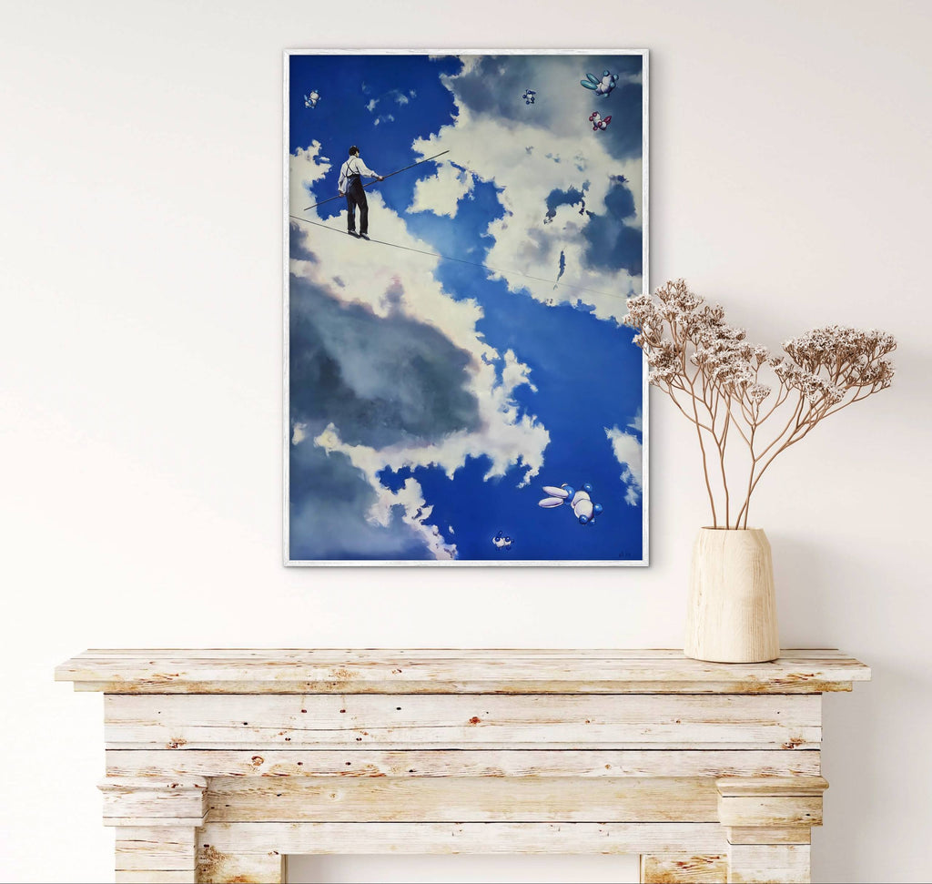 Framed artwork of a person in the sky above a wooden console table with a vase of dried flowers.