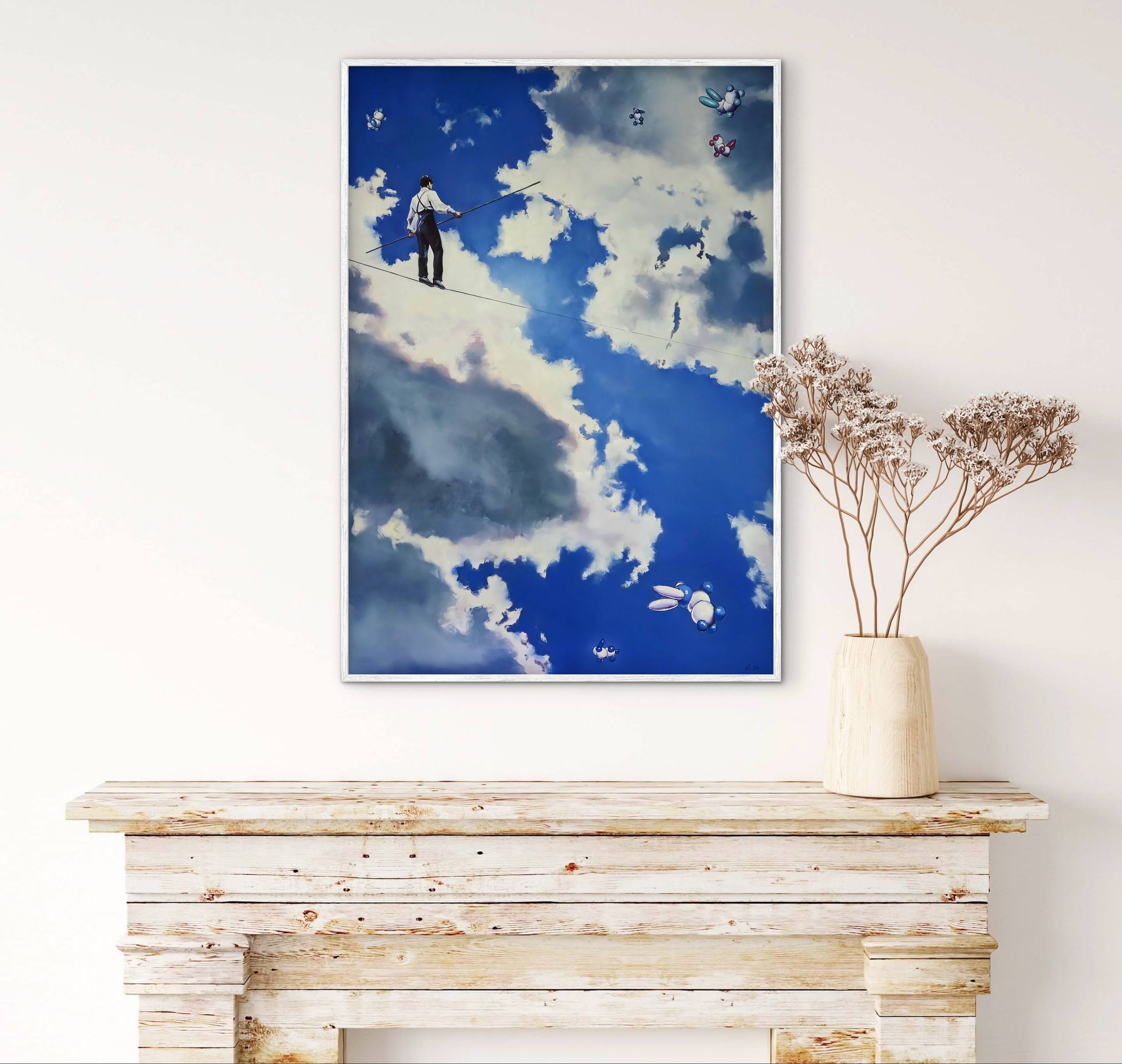 Framed artwork of a person in the sky above a wooden console table with a vase of dried flowers.