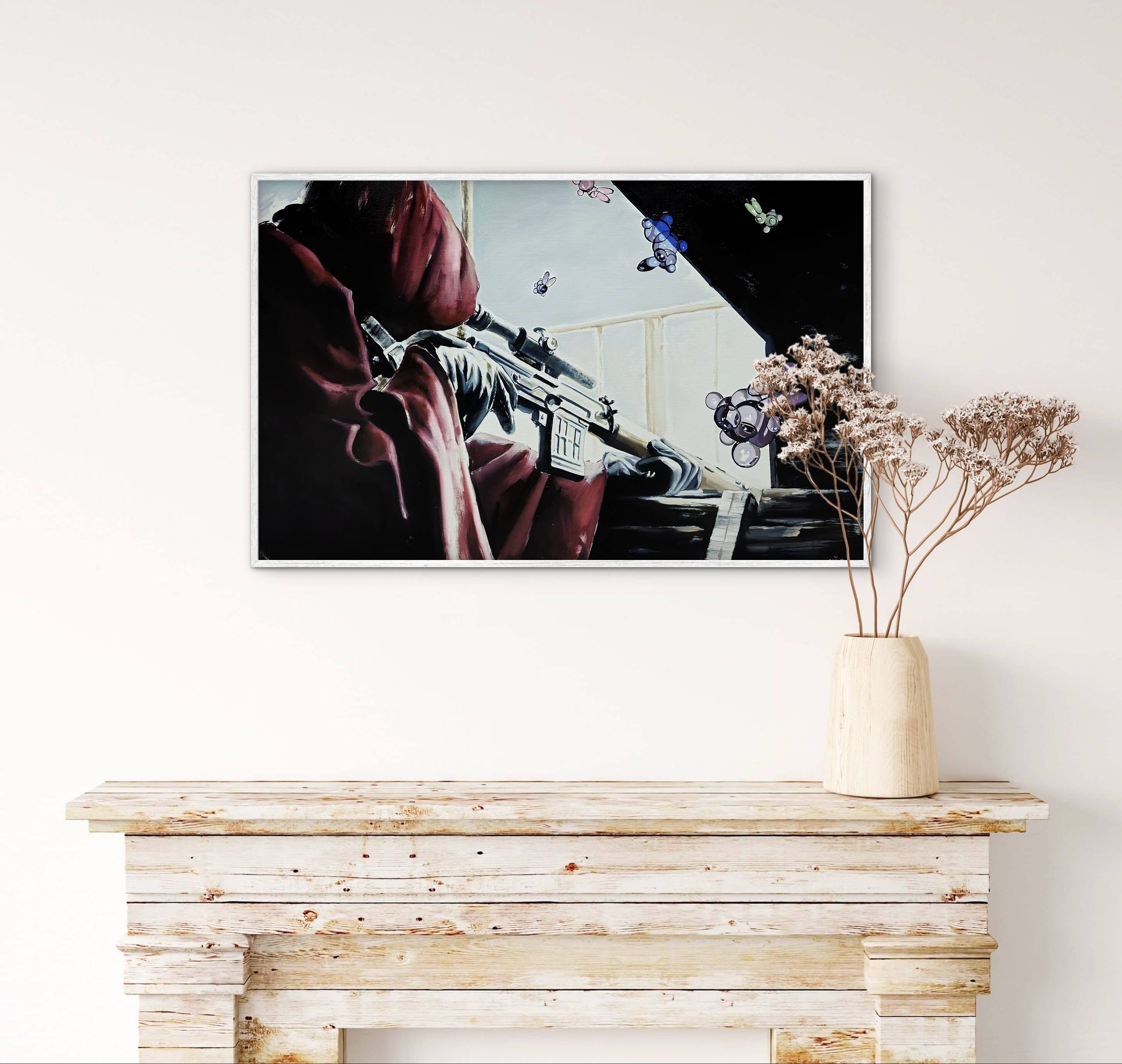 Framed artwork on a wall above a wooden console table with a vase of dried flowers.