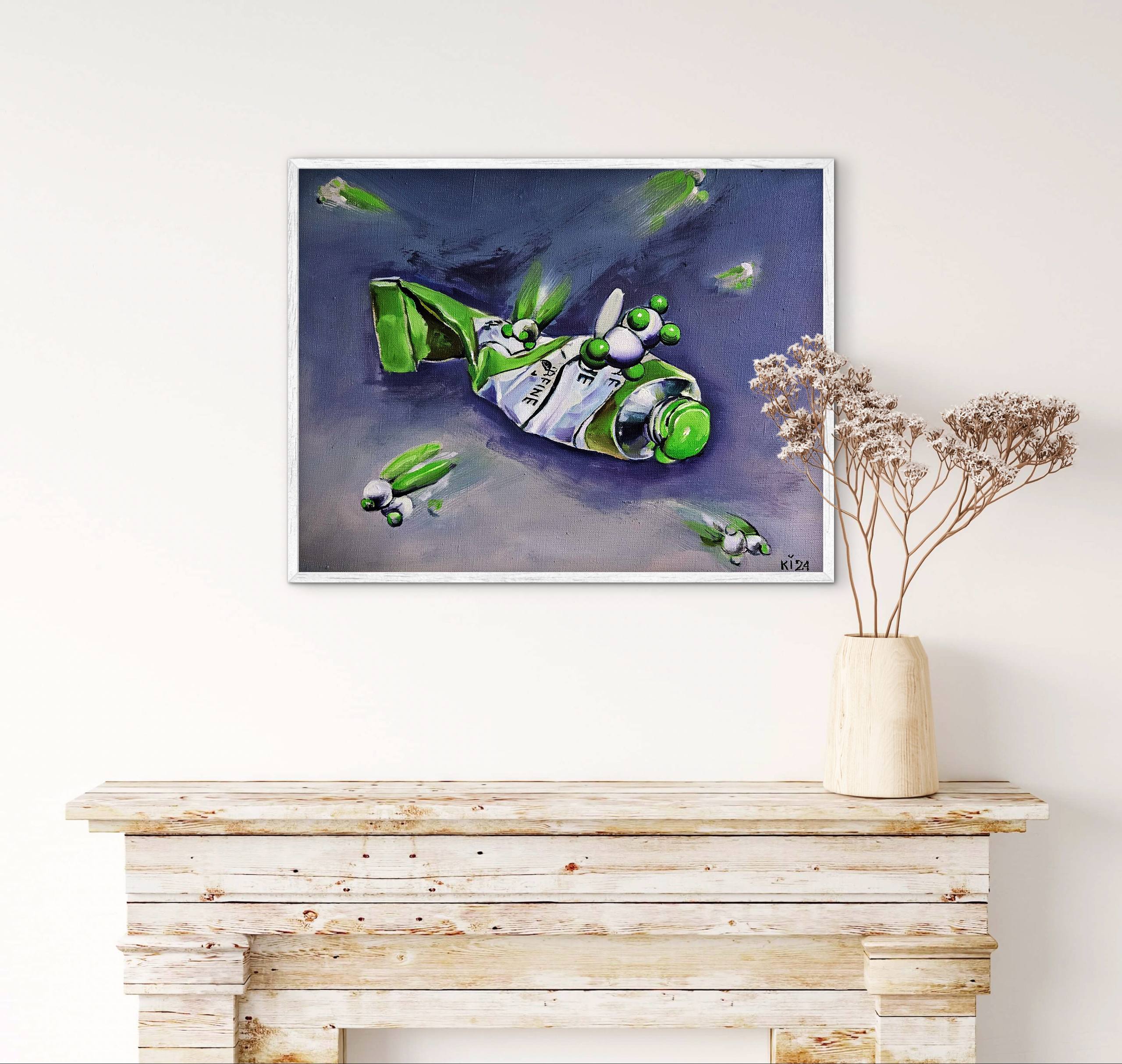 Framed artwork of a green bottle on a white wall above a wooden console table.