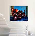 Framed artwork of a pomegranate with colorful seeds on a white wall.