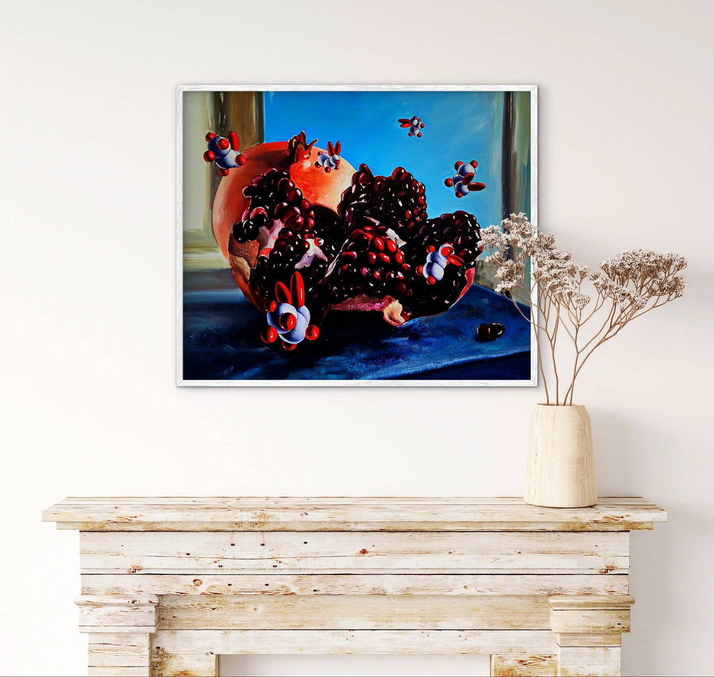 Framed artwork of a pomegranate and berries on a blue surface, displayed above a wooden console table.