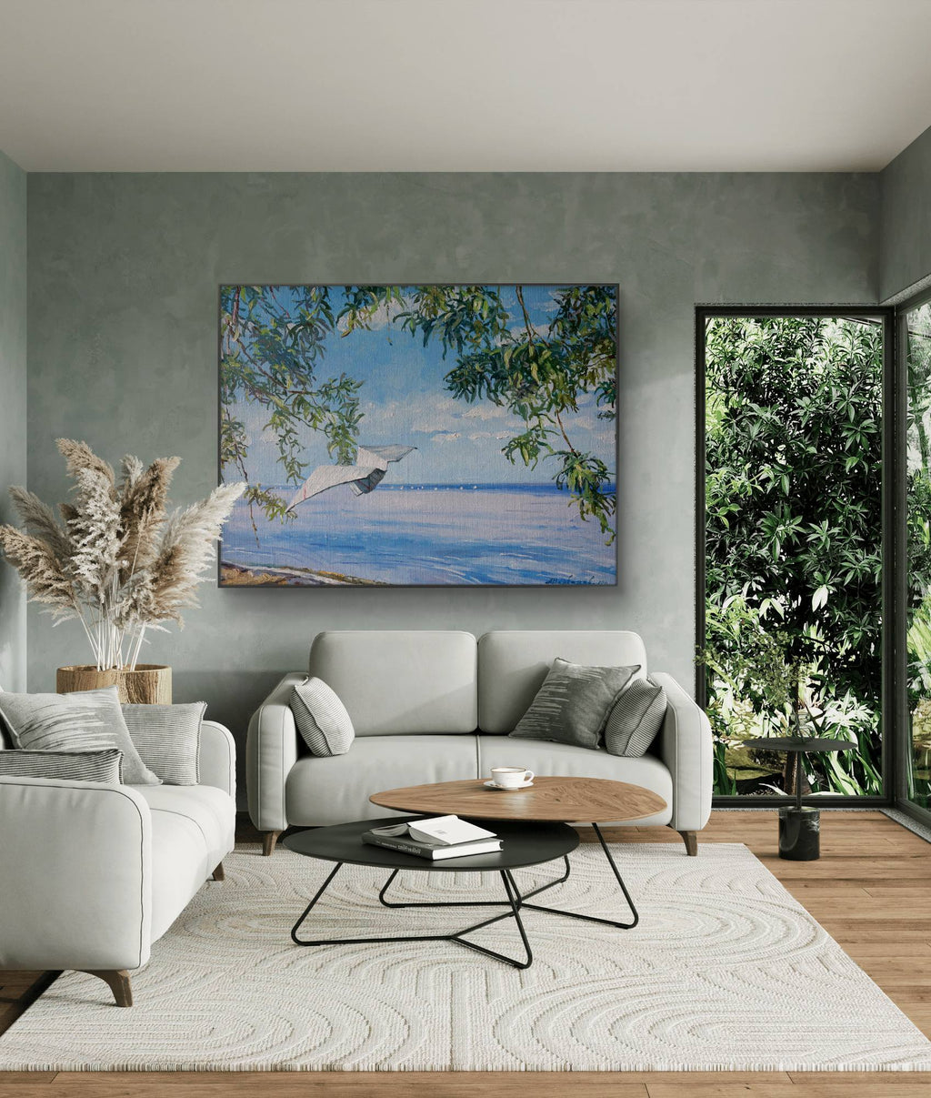 Modern living room with a gray sofa, coffee table, and decorative painting of dolphins.