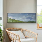 Living room with a flat-screen TV displaying a nature scene, a wicker chair, and a plant.