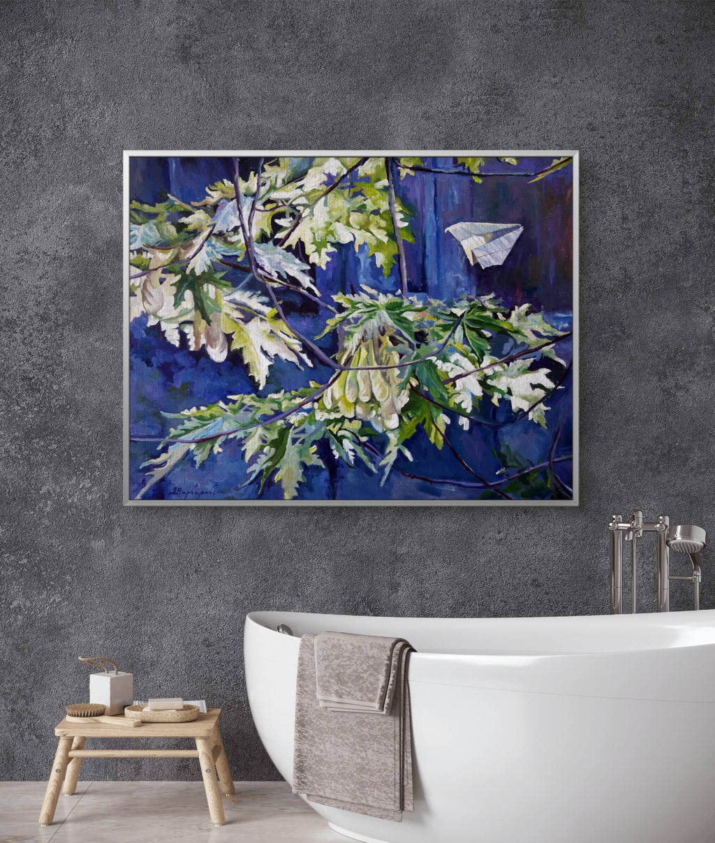 Bathroom with a large painting of a leafy branch on a gray wall above a white bathtub.