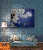 Blue patterned wallpaper with a decorative sofa and lamp in a room.
