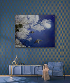 Modern living room with blue walls, a blue sofa, and a decorative painting of a butterfly and moon.