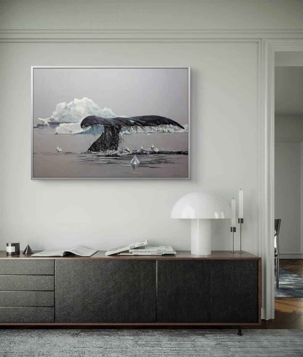 Framed artwork of a whale tail and iceberg on a wall above a wooden console table.