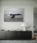 Framed artwork of a whale tail and iceberg on a wall above a wooden console table.