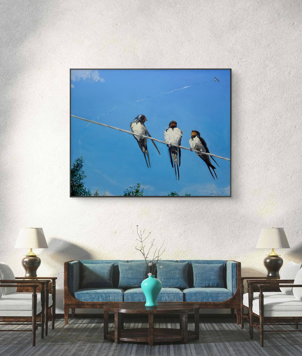 Framed artwork of birds on a wire above a living room setting.