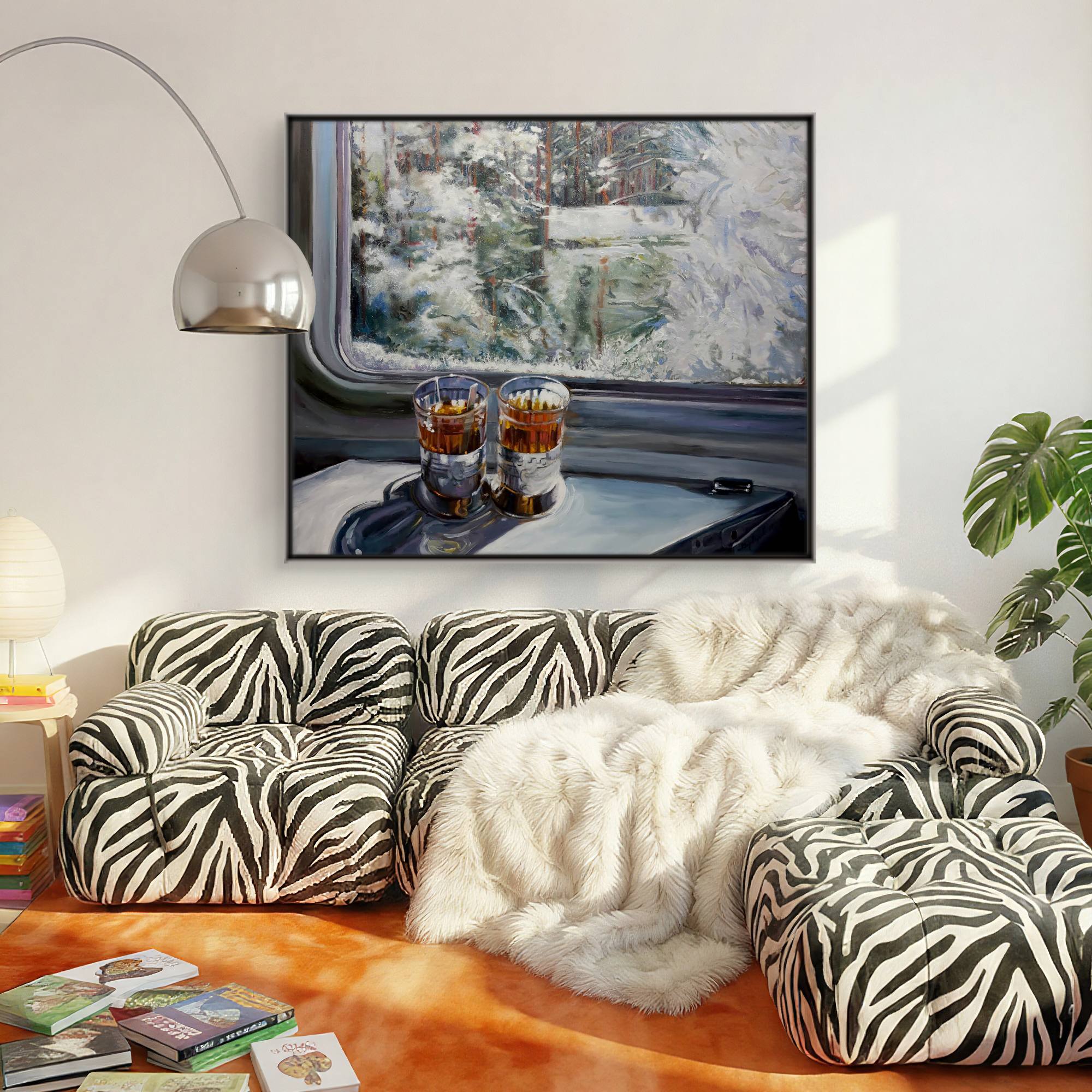 Living room with zebra-patterned sofa, white fur throw, and framed artwork of a train interior.