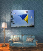 Living room with a blue sofa, lamp, and wall art of kites.