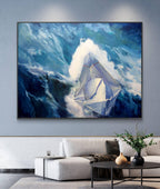 Framed painting of a sailboat in the mountains on a wall above a sofa.