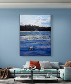 Framed artwork of a coastal scene hanging on a blue wall above a sofa.