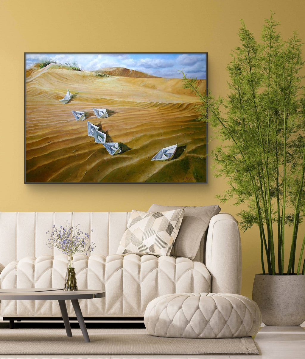 Living room with a large painting of a desert landscape on the wall, featuring a sofa and decorative elements.