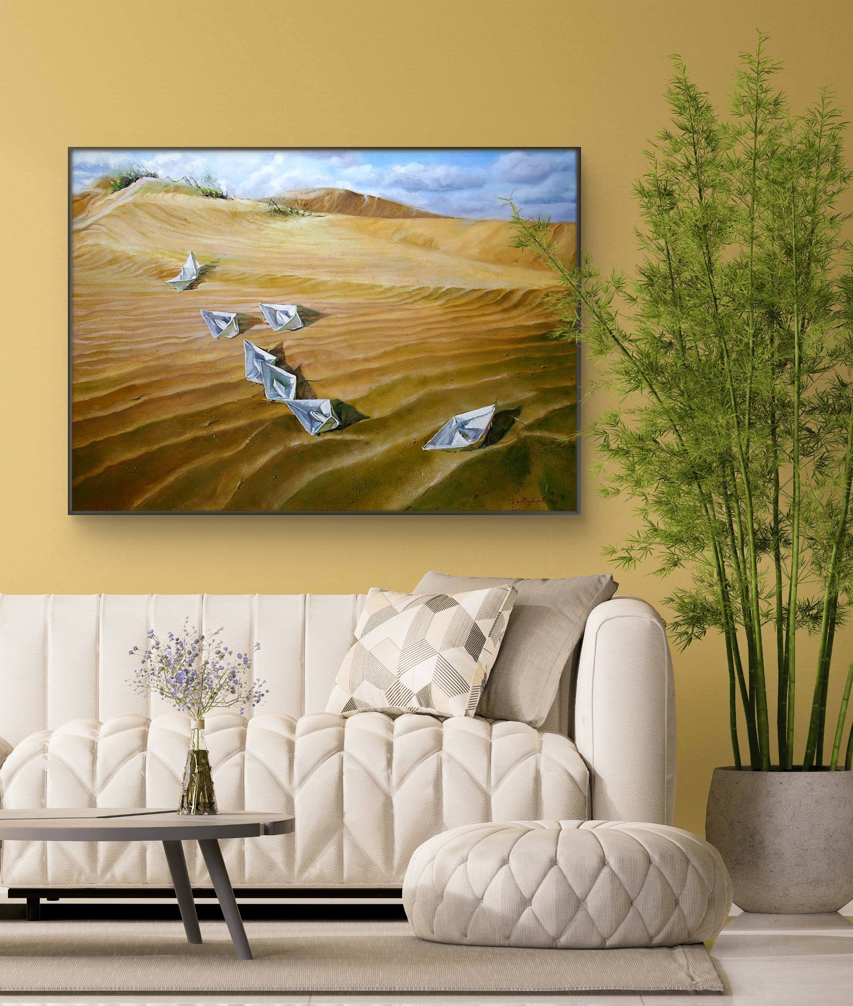 Living room with a large painting of a desert landscape on the wall, featuring a sofa and decorative elements.