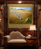 Framed painting of a desert landscape with birds on a wall above a sofa.
