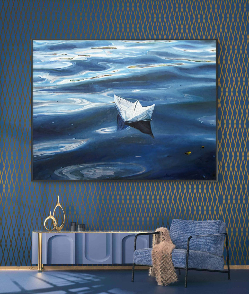 Framed artwork of a paper boat on water in a room with blue walls and furniture.