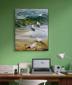 Painting of paper boats on a beach above a desk with a laptop and lamp.