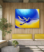 Modern interior with a painting of a diver on a wall above a yellow couch.