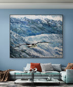 Framed artwork of a bird flying over water in a living room setting.