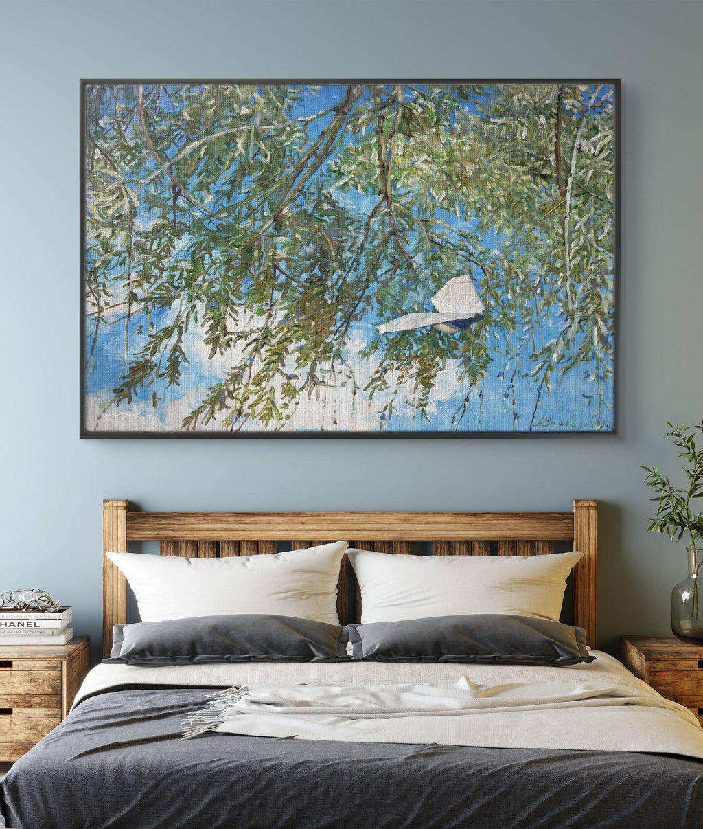 Framed nature painting above a bed in a bedroom