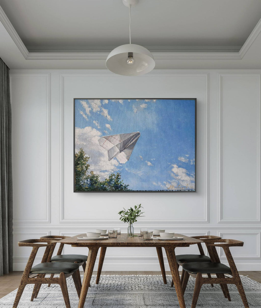 Dining room with wooden table and chairs, framed artwork of a paper airplane, and a vase on the table.